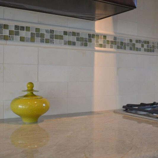 Cabinet top with Yellow decorative ceramic container, tiled back splash